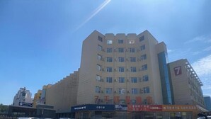 A multi-story building with a flat facade, several windows, and a prominent number '7' sign. - 7 Days Premium Beijing Changping Subway Station (Changping)