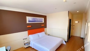A hotel room with a bed, a nightstand, a wall-mounted picture, and a door. - 7 Days Premium Beijing Changping Subway Station (Changping)