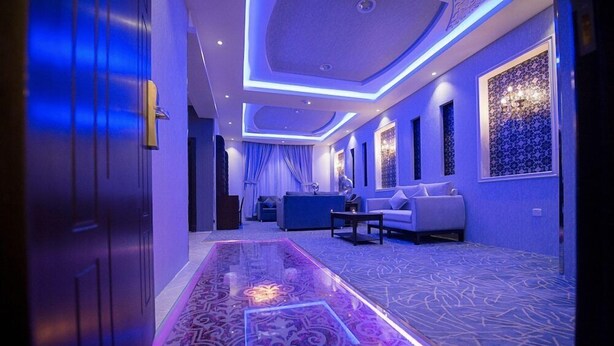 A hotel lobby with a patterned carpet, a reception desk, and a sofa. - Rest Night Serviced Apartments Wadi Al Dawasir (Wadi-Ad-Dawasir)