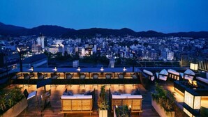 A rooftop terrace with seating and a cityscape view at dusk. - Shijo Kawaramachi Onsen Soraniwa Terrace Kyoto (Kyoto)