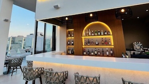 A rooftop bar with a neon sign, bar stools, and a display of liquor bottles. - Ethereal White Resort Hotel & Spa Adults Only 16+ (Heraklion)