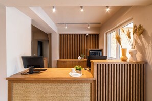A modern kitchen with a wooden countertop, a built-in oven, and a window with plants. - Skiathos Theros (Skiathos)