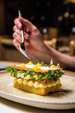 A dessert with mint leaves and yellow elements on a plate. - Skiathos Theros (Skiathos)