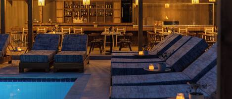 A poolside area with lounge chairs and a bar.