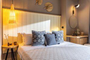 Ein ordentlich eingerichtetes Schlafzimmer mit Bett, Kissen, Nachttisch, Lampe und Wanddekoration.