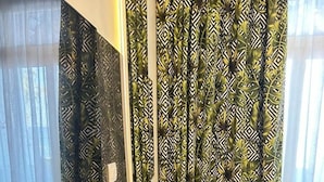 A modern room with a glass table, a black coffee machine, a yellow chair, and patterned curtains. - Naama Bay Suites & Spa - Sharm (Sharm El Sheikh)