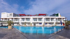 A hotel with a large pool, multiple balconies, and a modern architectural design. - Naama Bay Suites & Spa - Sharm (Sharm El Sheikh)