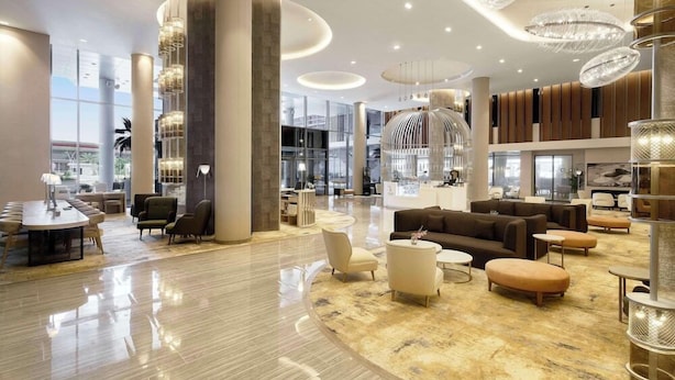 A spacious lobby with high ceilings, large columns, and modern lighting fixtures. - Radisson Blu Hotel Riyadh Convention & Exhibition Center (Riyadh)