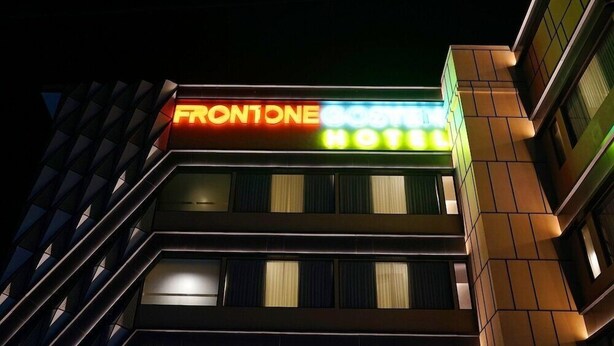 Un letrero de hotel con el nombre "FRONTONE" y "HOTEL" en letras iluminadas.