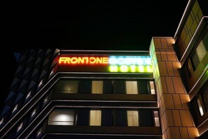 A hotel sign with the name "FRONTONE" and "HOTEL" in illuminated letters. - Front One Gosyen Hotel Salatiga (Salatiga)