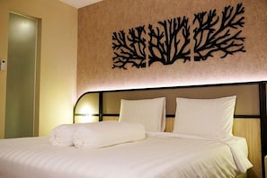 Una habitación de hotel con una cama, ropa de cama blanca y una decoración de estructuras similares a árboles.