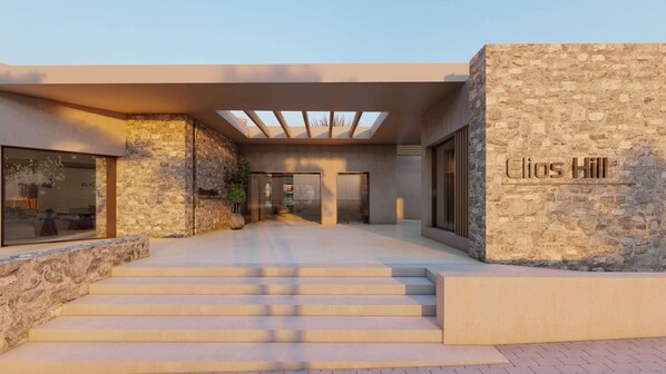 A modern building entrance with a stone facade, a glass door, and a staircase leading to the entrance.