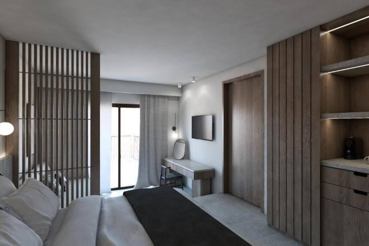 A modern hotel room with a bed, a desk, a chair, a wardrobe, and a large window.