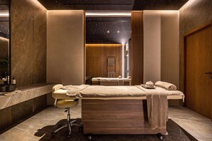 A spa room with a massage table, a wooden bench, and a starry ceiling design. - Elios Hill (Hersonissos)