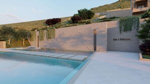 A modern spa with a pool, a stone wall, and greenery. - Elios Hill (Hersonissos)