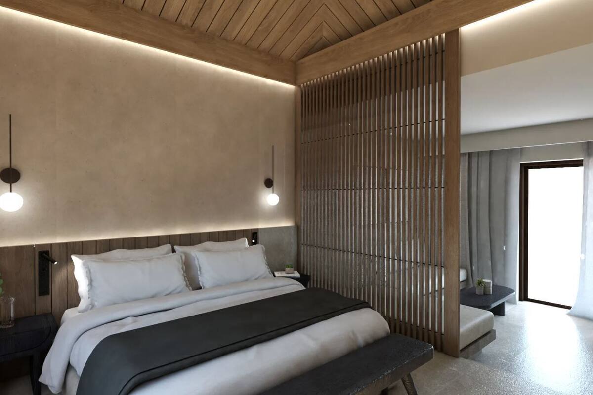 A modern bedroom with a large bed, bedside tables, a wooden partition, and a view of the outside.