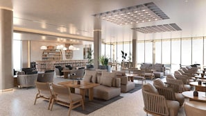 A spacious lobby with a central seating area, a library, and large windows. - Elios Hill (Hersonissos)