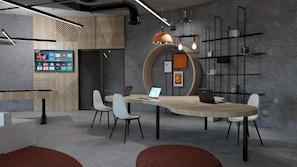 A modern office space with a round table, chairs, a laptop, a TV, and a bookshelf. - Elios Hill (Hersonissos)