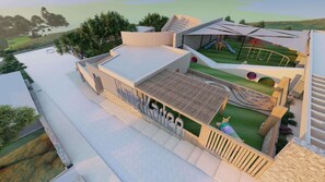 A modern building with a flat roof, a covered outdoor area with a slide, and a landscaped garden. - Elios Hill (Hersonissos)