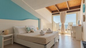 A bedroom with a bed, bedside table, and a view of the sea. - Hotel da Cesare - Maluentu (San Vero Milis)