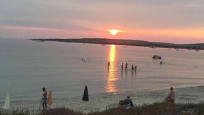 A sunset over a calm sea with boats and people enjoying the water. - Hotel da Cesare - Maluentu (San Vero Milis)