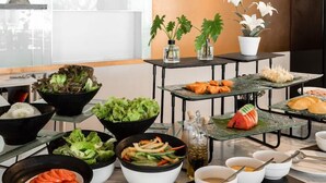 A buffet with various dishes including salads, vegetables, and a watermelon. - Sirin Exclusive Hotel and Residence (Pattaya)