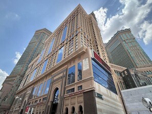 A tall, modern building with a prominent entrance and large windows. - Al Safwa Tower 3 Hotel -EX (Makkah)