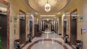 A hotel lobby with marble floors, ornate ceiling design, and multiple elevators. - Al Safwa Tower 3 Hotel -EX (Makkah)