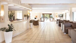 A spacious lobby with a reception desk, seating area, and large windows.