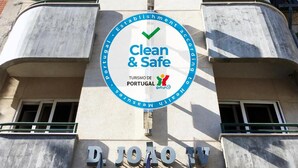 Un edificio con un cartel que dice 'Clean & Safe' y 'Turismo de Portugal', indicando un enfoque en limpieza y seguridad.