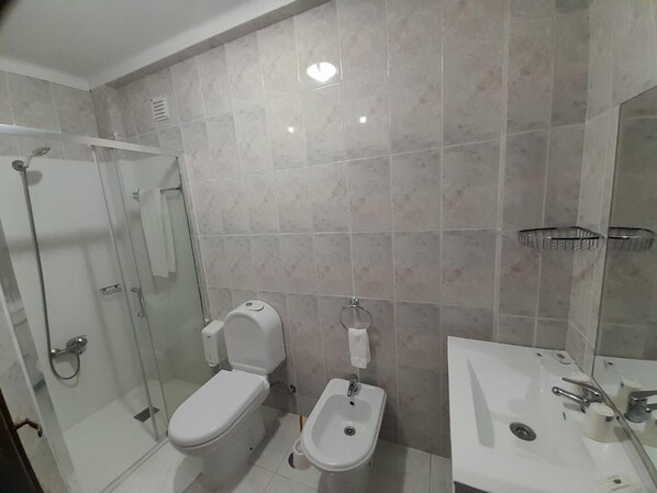 A modern bathroom with a toilet, bidet, and sink. - Hotel Dom Joao IV (Guimarães)