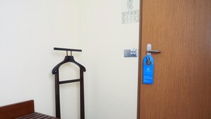 A room with a wooden bench, a coat rack, a door with a blue tag, and a bulletin board on the wall. - Hotel San Francisco (Leiria)