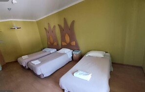 A hotel room with two single beds, a nightstand, a lamp, and a wall-mounted shelf. - Hotel Vitoria (Santarém)