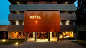 A modern hotel with a prominent 'HOTEL' sign, multiple floors, and a well-lit entrance. - Paredes Design Hotel (Paredes)
