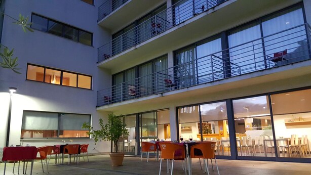 A multi-story building with outdoor seating and a restaurant. - Hotel Jose Alberto (Viseu)