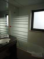 Un baño con lavamanos, espejo y ventana.