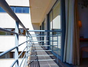 A balcony with a metal railing, large windows, and a view of the building's interior. - Hotel Jose Alberto (Viseu)