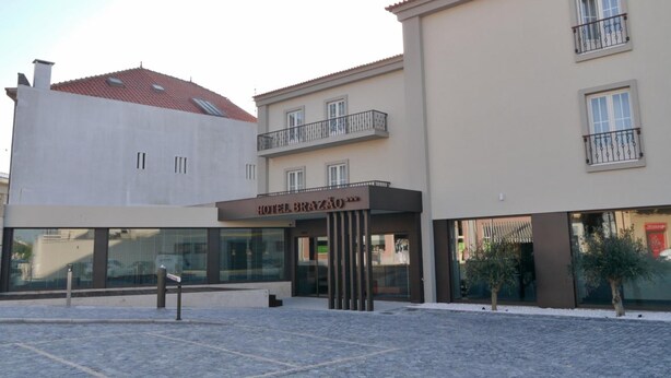 Ein Hotel mit moderner Fassade, überdachter Eingangspartei und einem Kopfsteinpflasterhof.