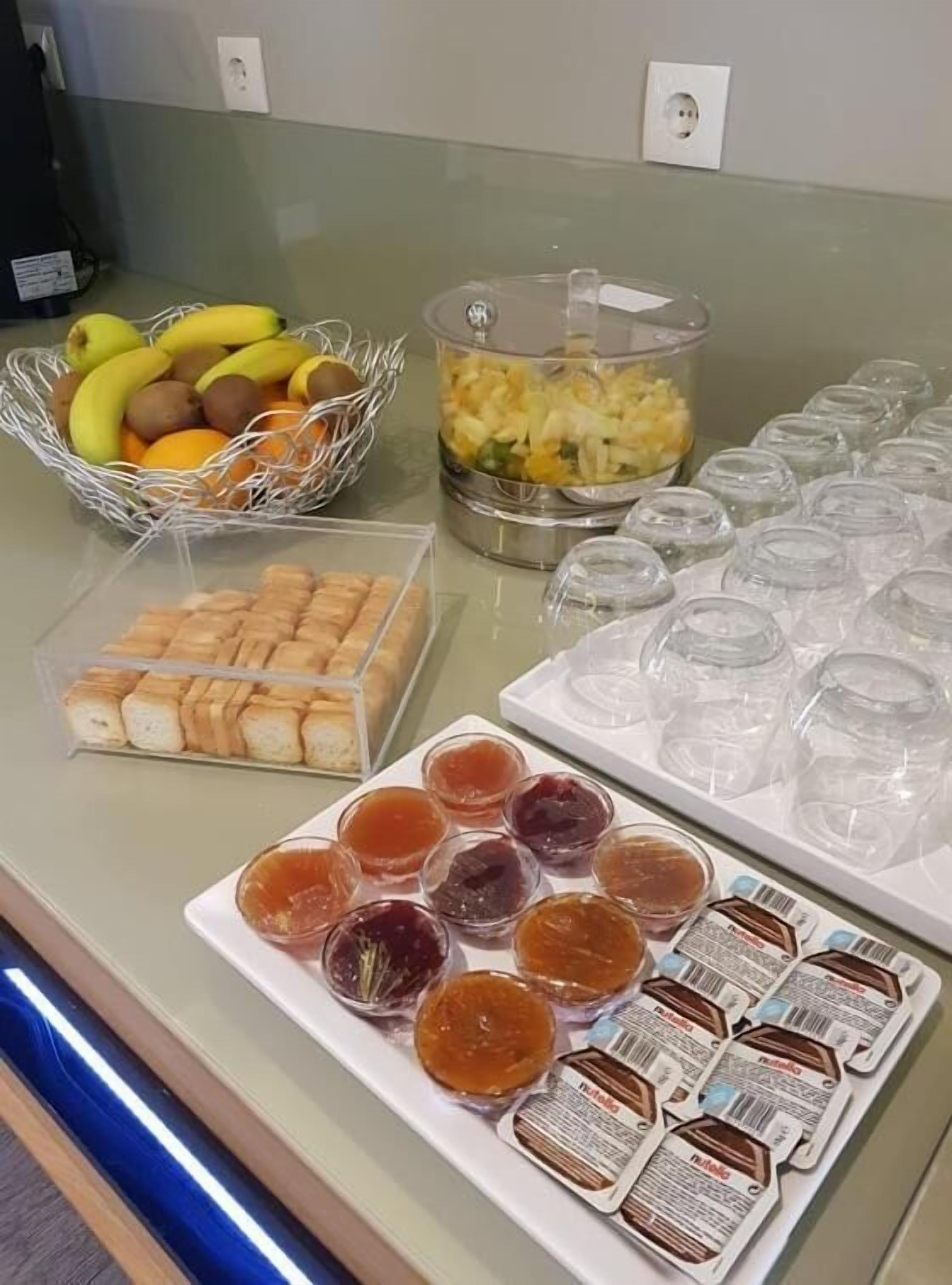 En buffé med ett varierat utbud av mat, inklusive frukt, bakverk och tillbehör.