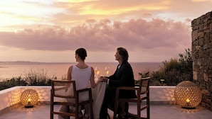 Two people seated at a table with a view of the sea and sunset. - Deos Mykonos (Mykonos)