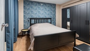 Ein Schlafzimmer mit einem Bett, einem Kleiderschrank und einem kleinen Tisch.