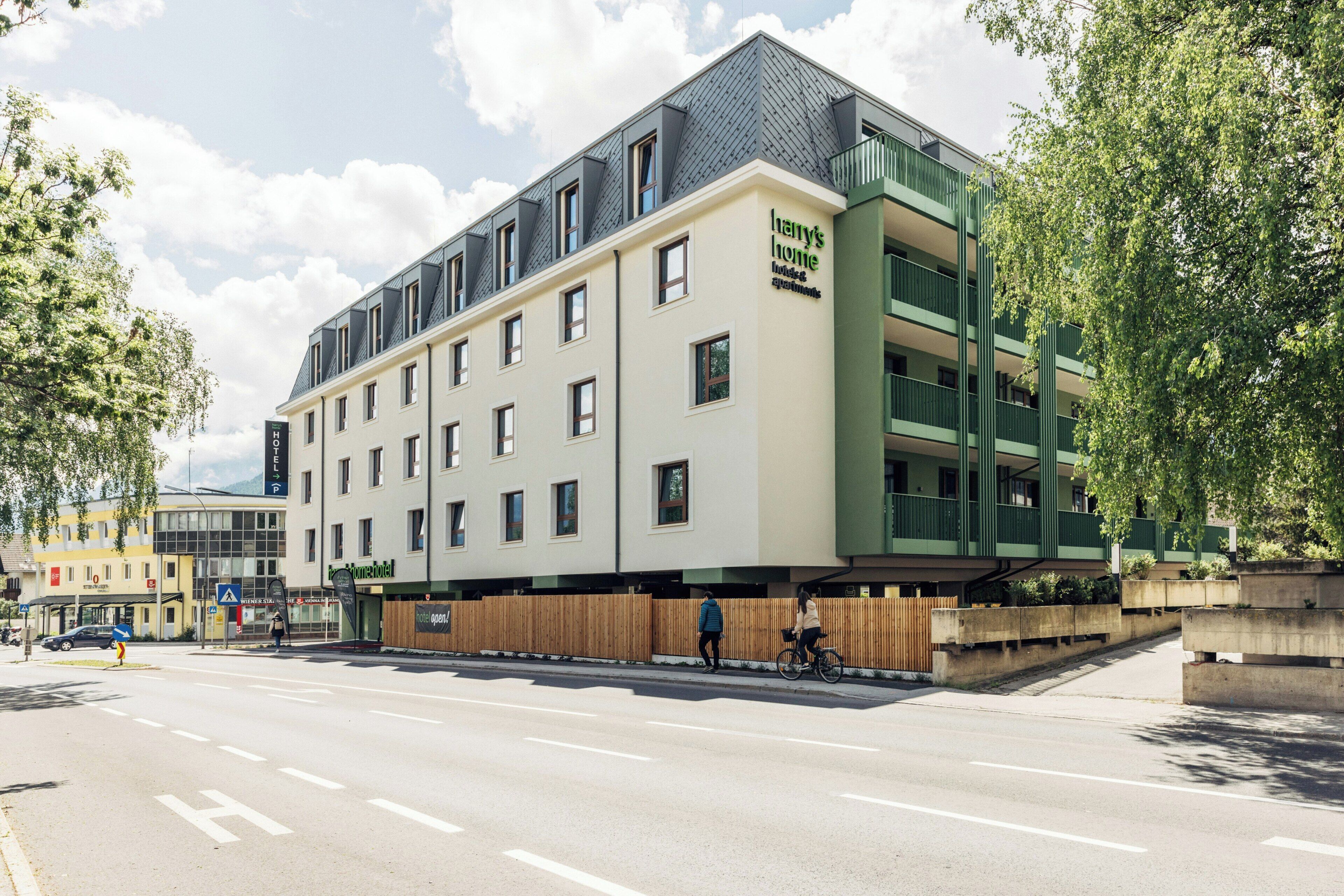 Un hôtel moderne doté d’un toit plat, de nombreuses fenêtres et d’une enseigne indiquant qu’il s’agit d’une résidence.