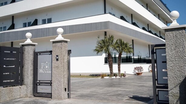 A modern hotel with a white facade, multiple balconies, and a gated entrance. - Pm Hotel (Catanzaro)