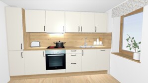 Een moderne keuken met witte kasten, een inbouwoven, een fornuis en een raam met een plant.