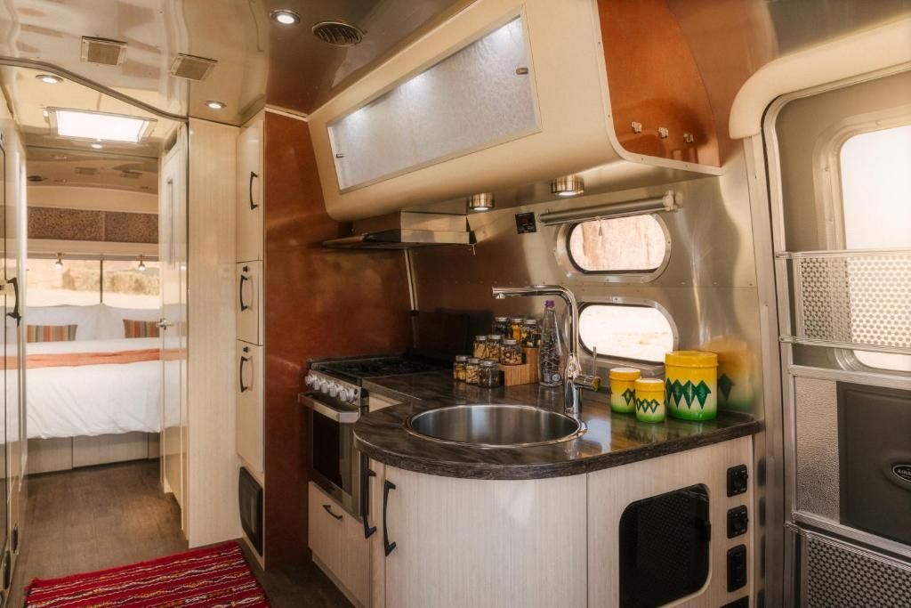 Una cocina compacta con estufa, lavamanos y alacenas.