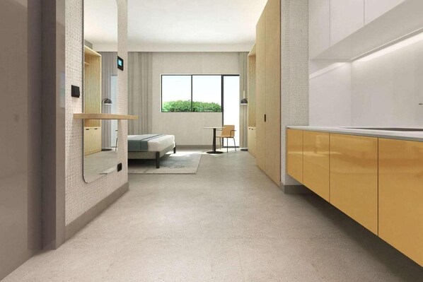 A modern hotel room with a bed, a small table, and a window with a view of greenery. - Adagio Apart Hotel (Abidjan)
