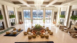 A spacious lobby with a central seating area, large windows, and a view of a pool. - Rixos Radamis Sharm El Sheikh (Sharm El Sheikh)