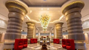 A lobby with a central chandelier, red seating, and large decorative columns. - Rixos Radamis Sharm El Sheikh (Sharm El Sheikh)