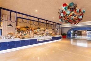 Un vestíbul d'hotel espaiós amb una zona de bar central, una gran pèndol decorativa i un disseny de sostre modern.