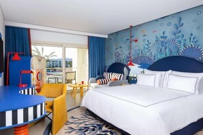 Une chambre d’hôtel avec un lit, un bureau, une chaise et une vue sur l’extérieur.